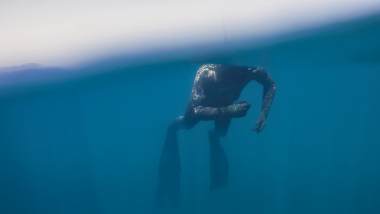 Diver descending in blue water