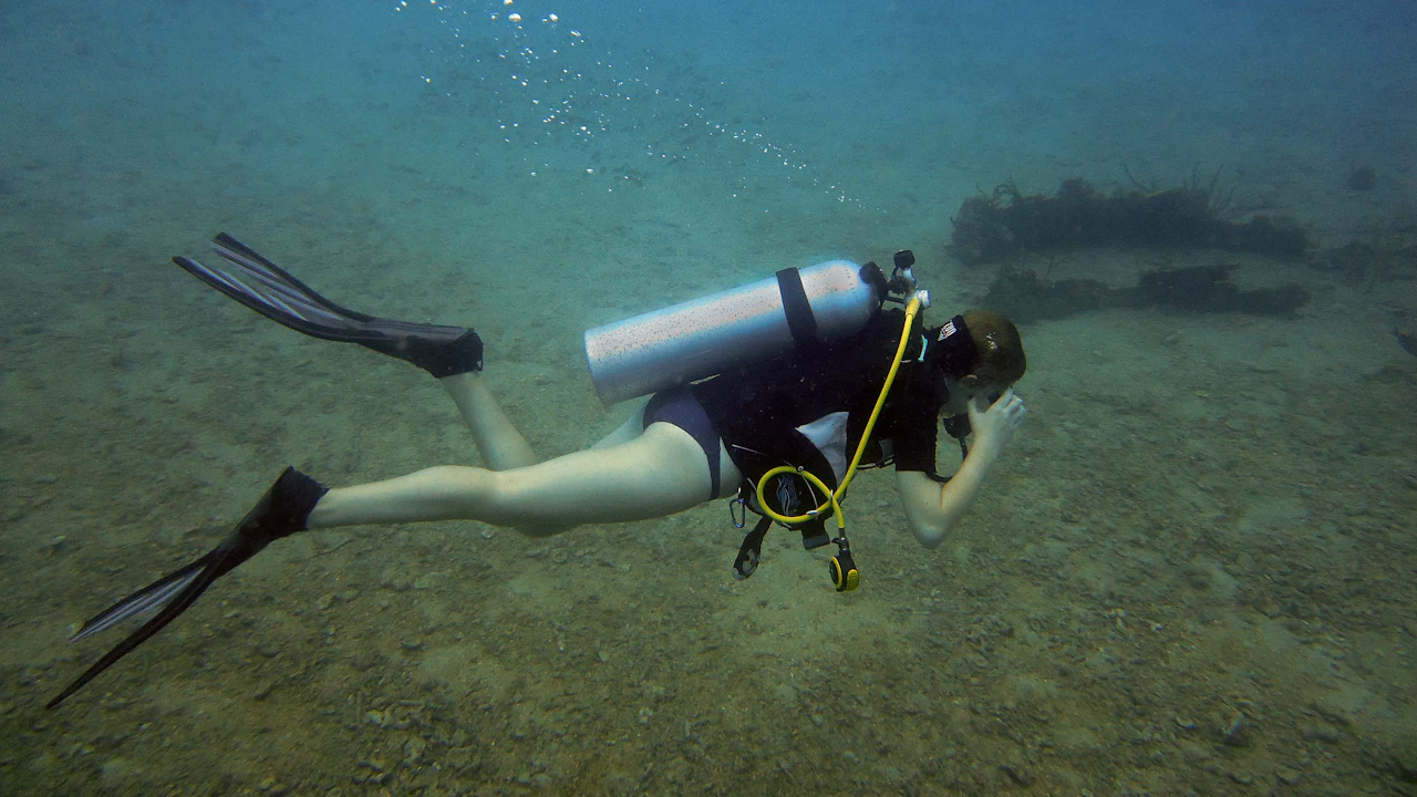 Scuba diver checking the pressure gauge on a console underwater