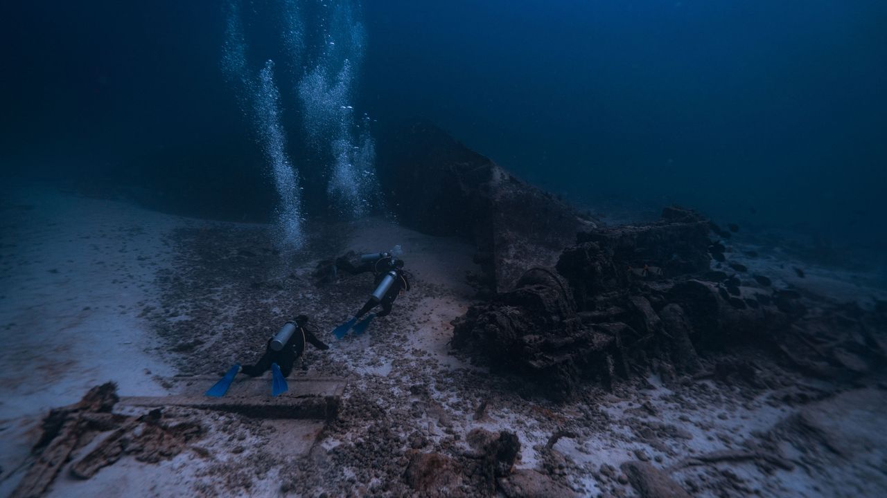 Scuba divers near the seabed with bubbles rising