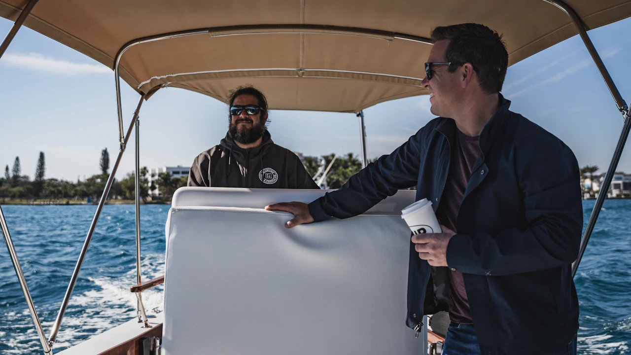 Two men talking under the canopy of a boat