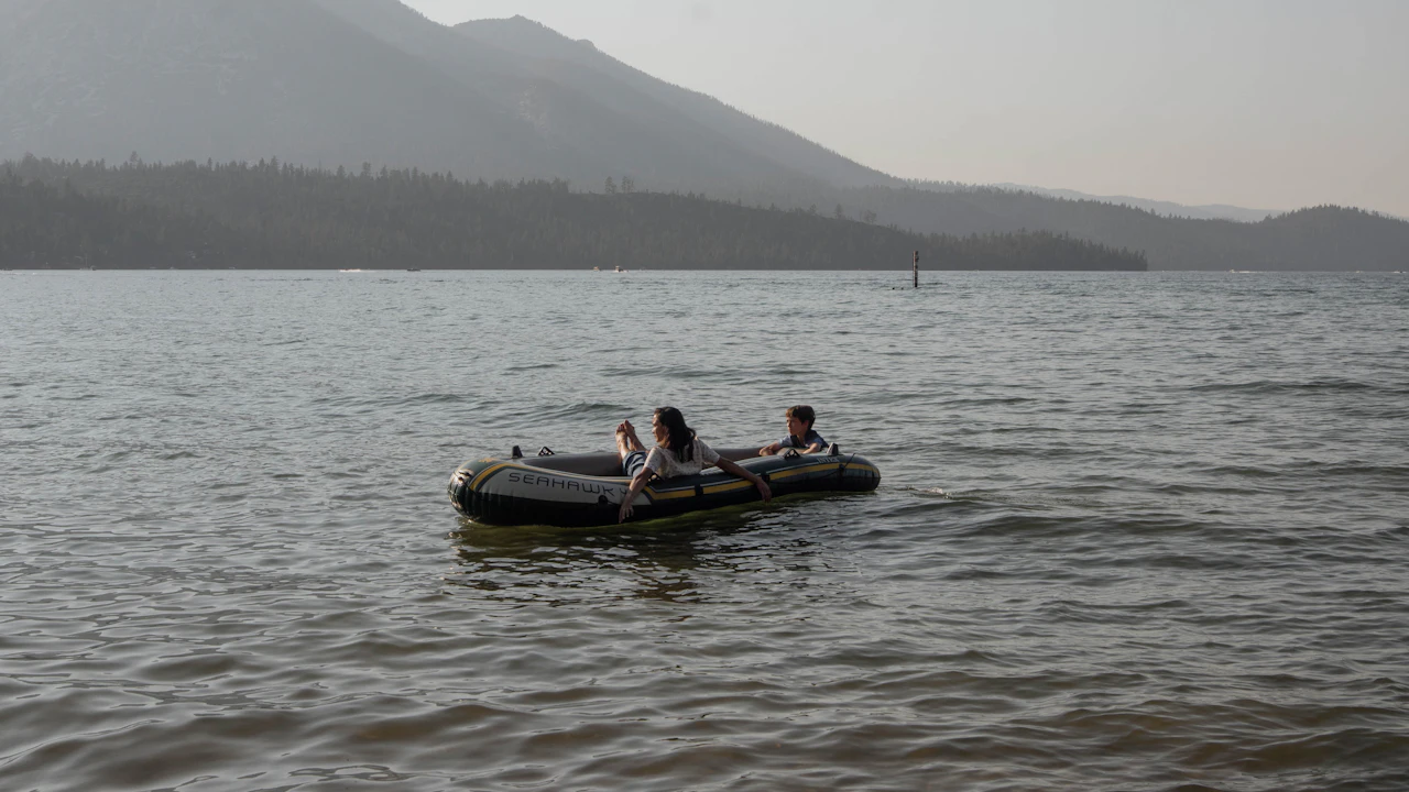Small inflatable boat with people on calm water