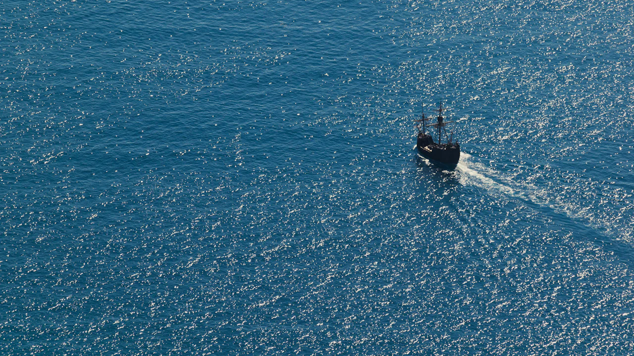 Small boat moving across open blue sea