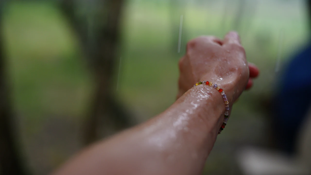 Person arm with a beaded bracelet outdoors