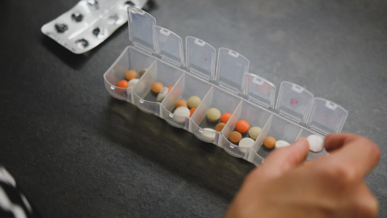 Pill organizer with tablets on a dark table