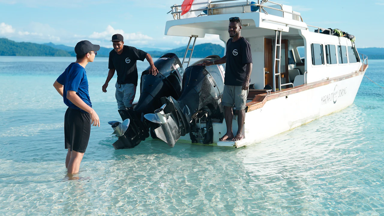 Group standing beside a boat in shallow water