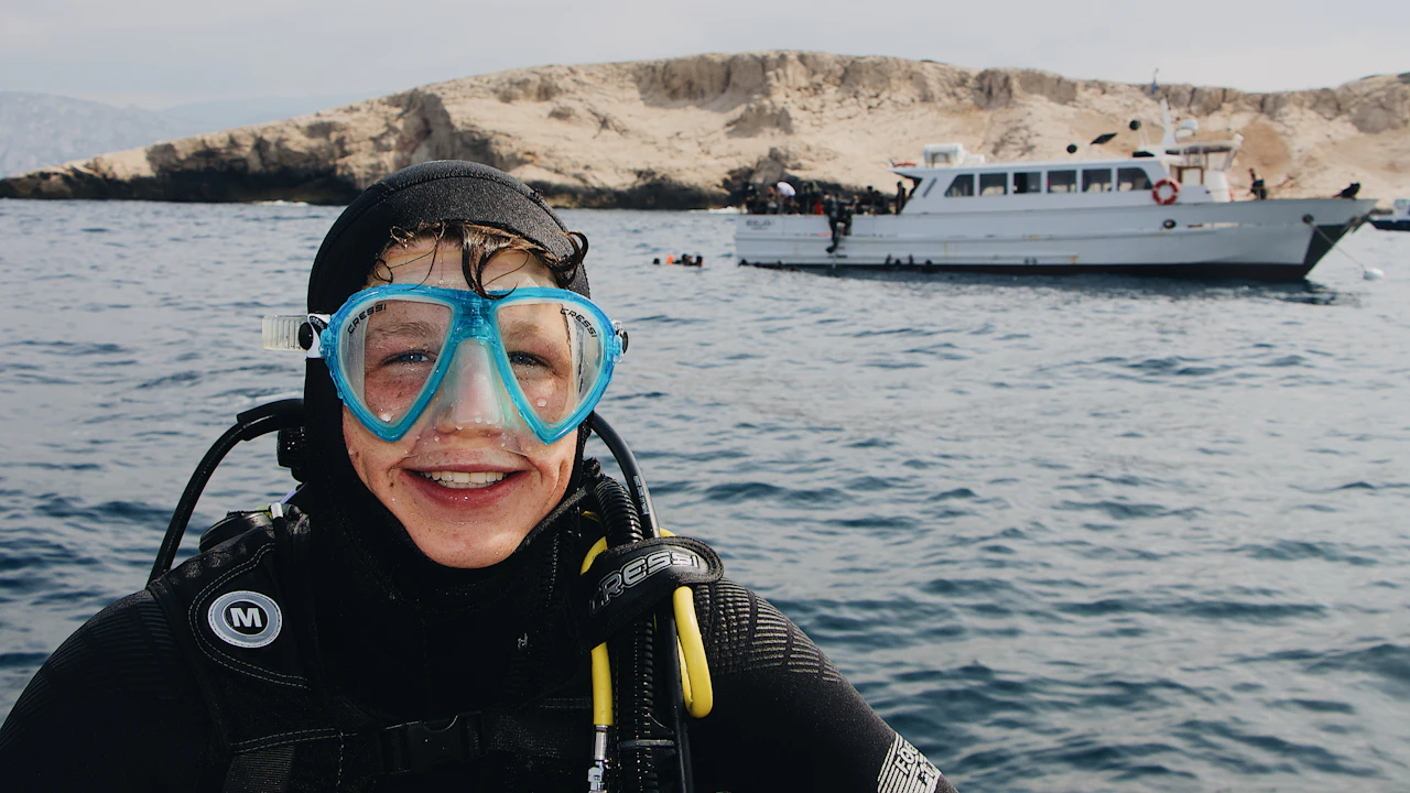 Smiling young diver in a mask on a boat