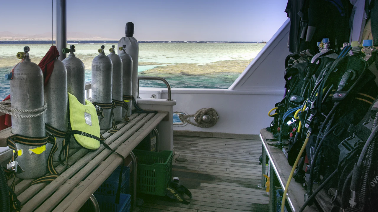 Scuba tanks and BCDs racked on the deck of a dive boat
