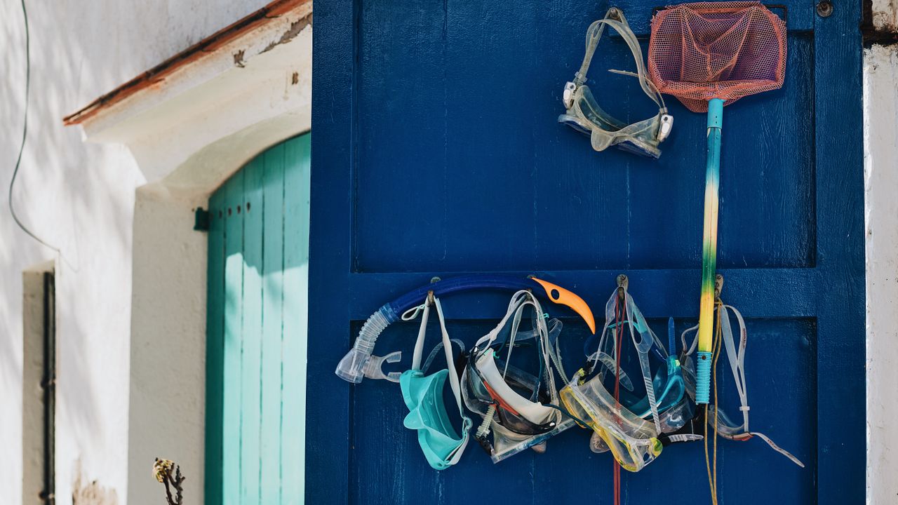 Masks and snorkels hanging on a painted door