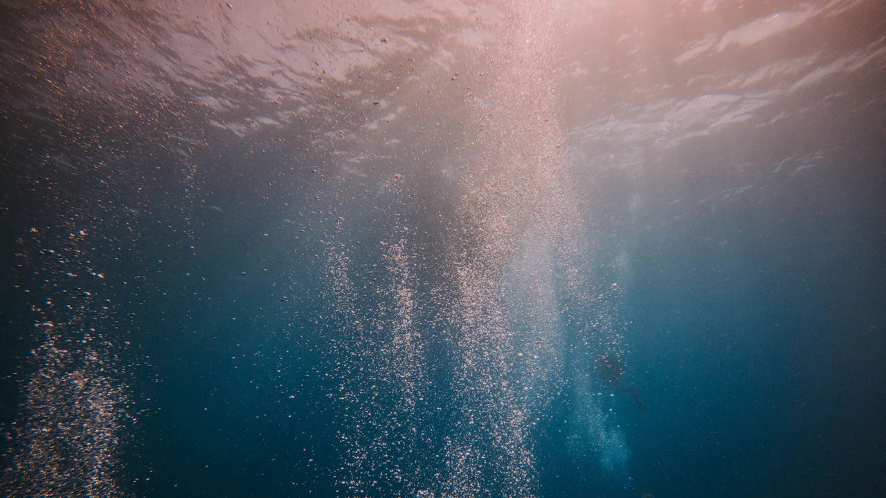 Bubbles rising through deep blue water
