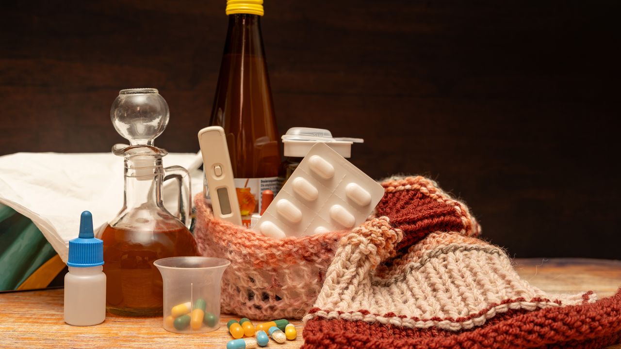 Cold remedies, tablets and a thermometer on a wooden table