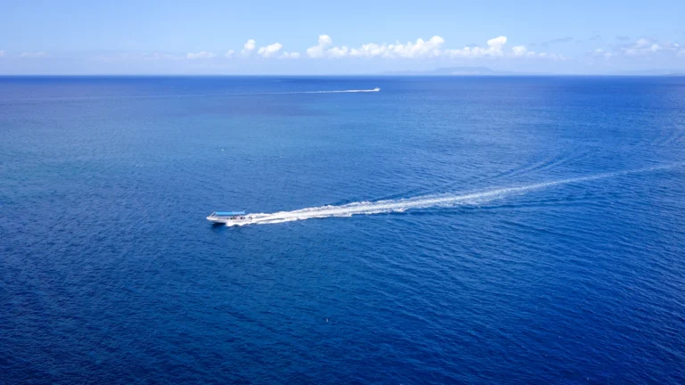 Boat speeding across deep blue water