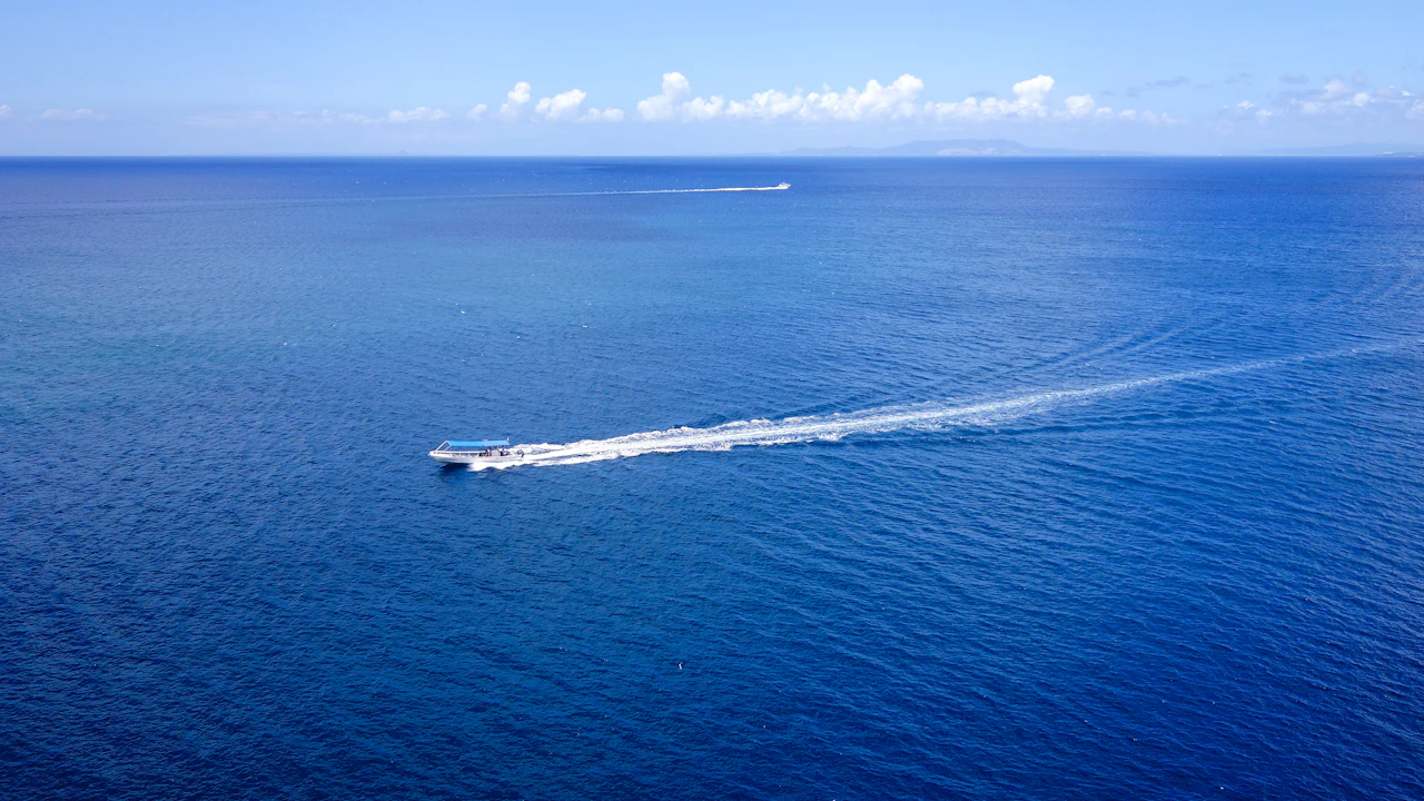 Boat speeding across deep blue water