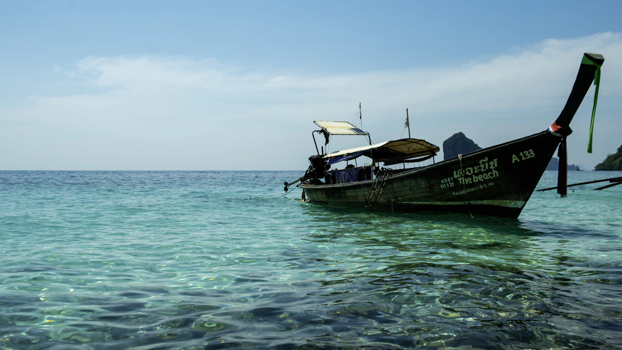 Long-tail boat moored in calm turquoise water