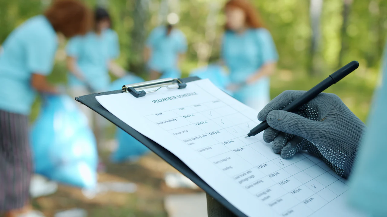 Person filling in a paper health questionnaire on a clipboard at a table