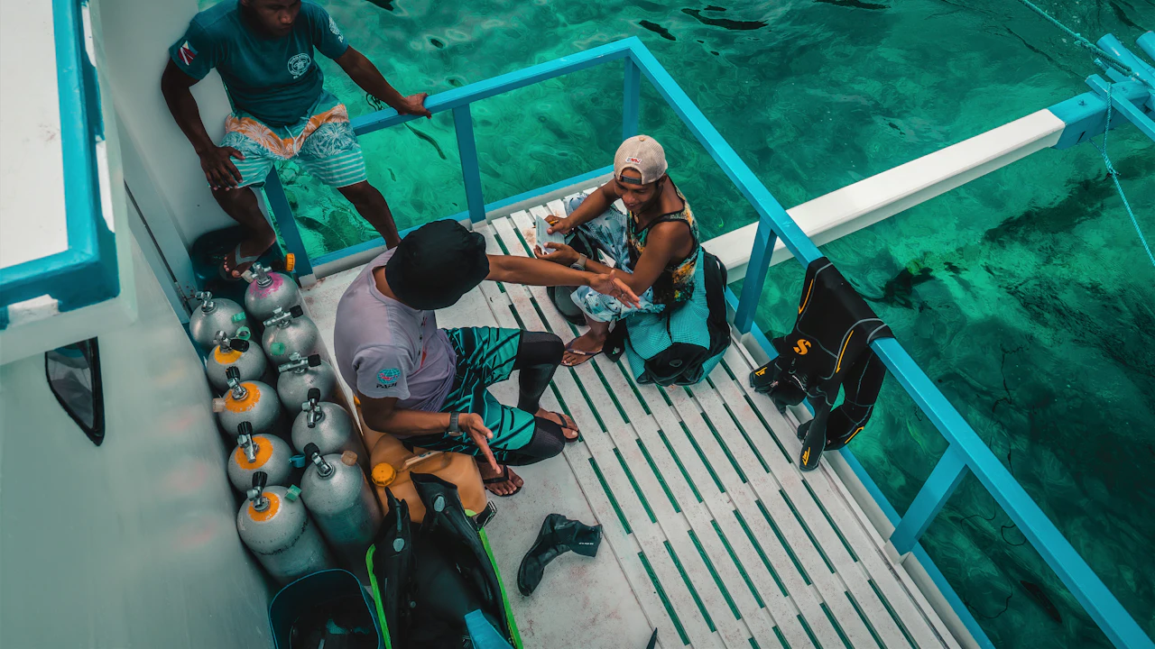 Divers preparing scuba gear on the deck of a dive boat