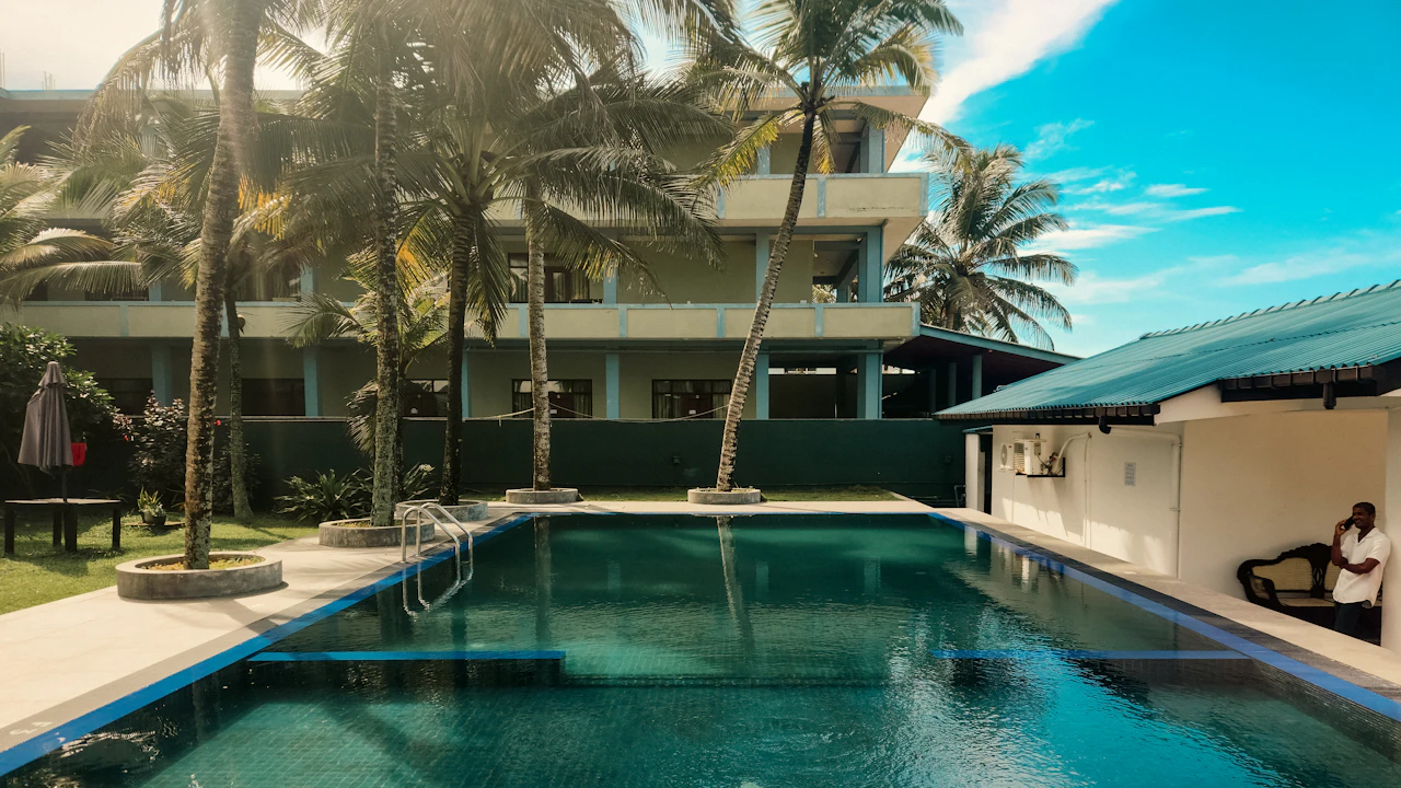 Resort swimming pool surrounded by palm trees on a sunny day