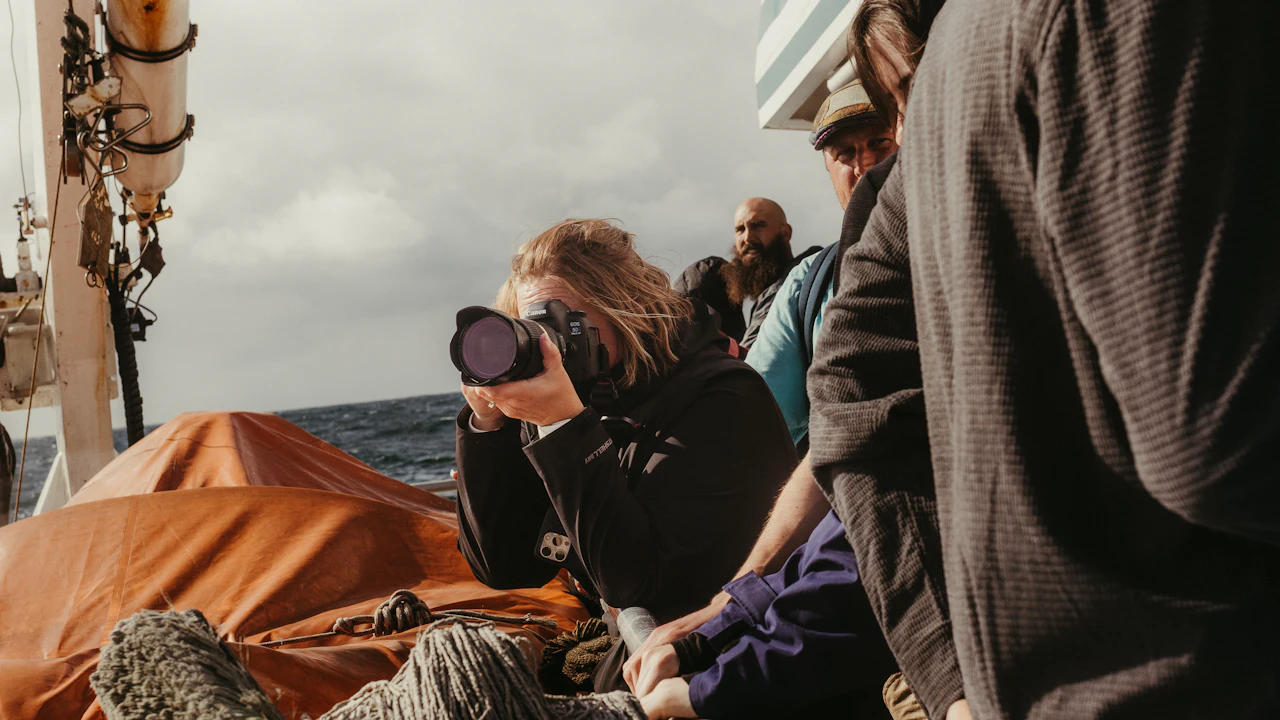 People in wetsuits sitting together on a boat deck