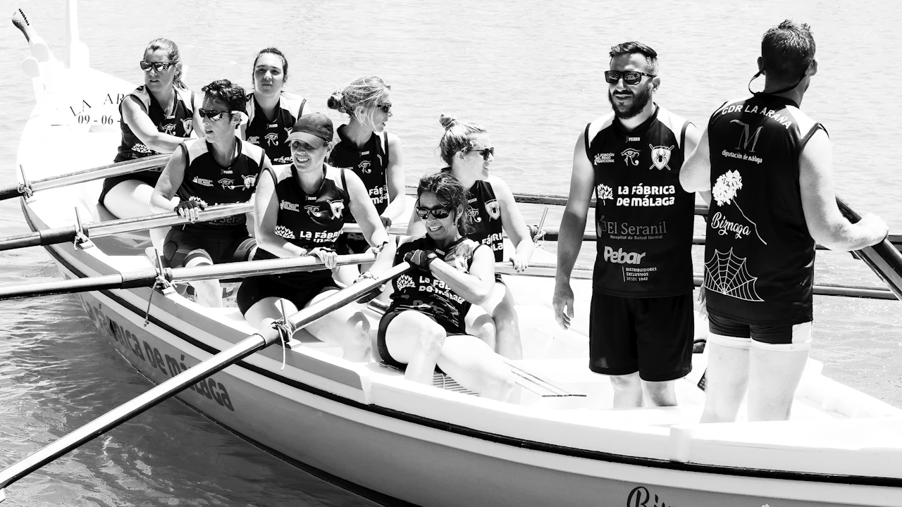 Scuba instructor talking with students in wetsuits on a boat deck