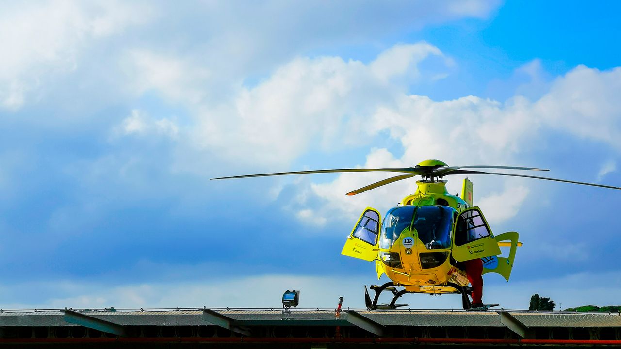 Medical helicopter waiting on a helipad with its rotor blades still
