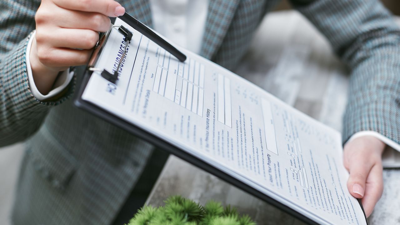 Person reading documents on a clipboard