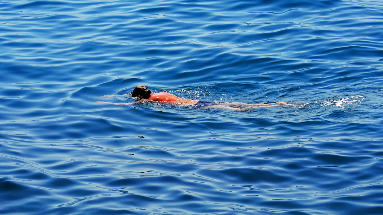 Swimmer doing front crawl through calm open sea water on a stamina swim
