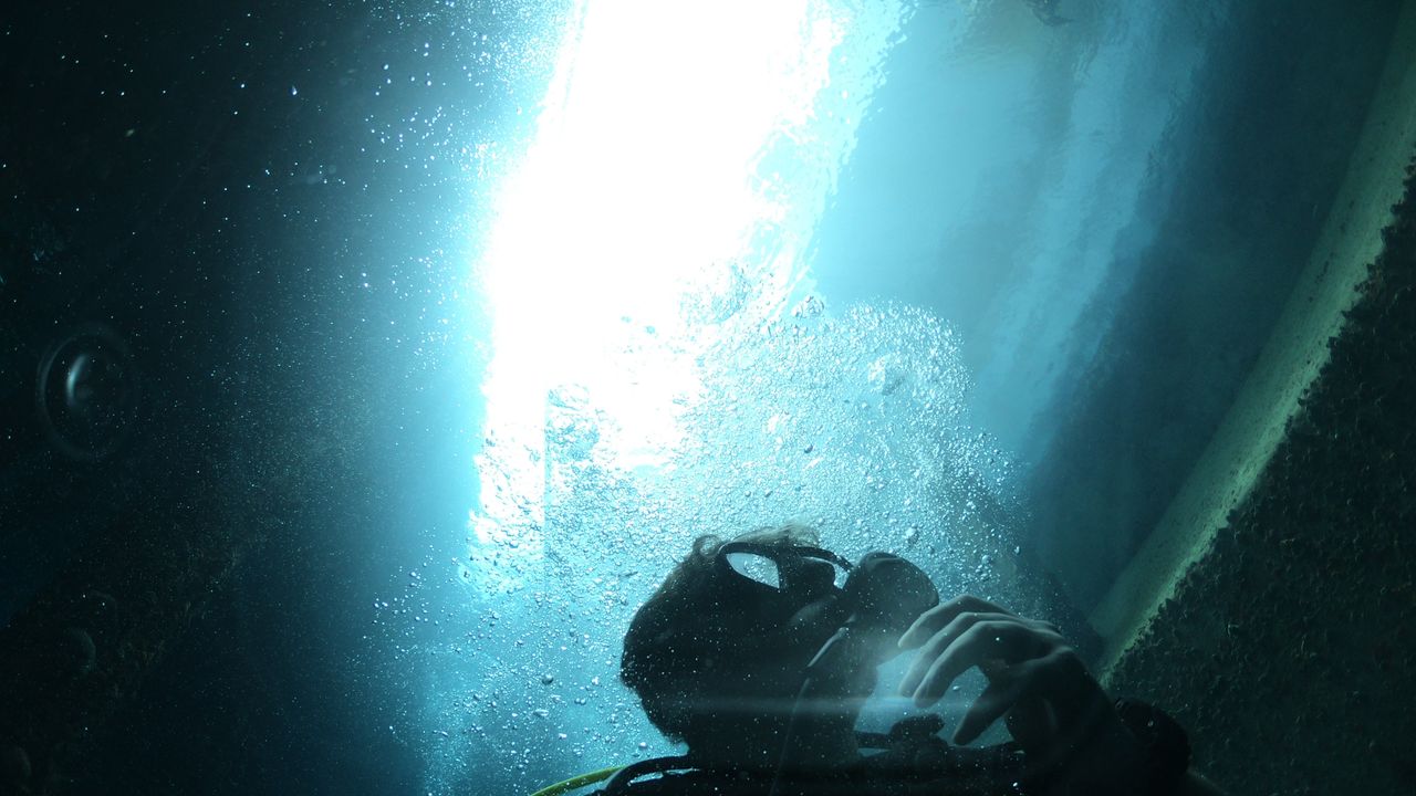 Scuba diver below a beam of light from the surface