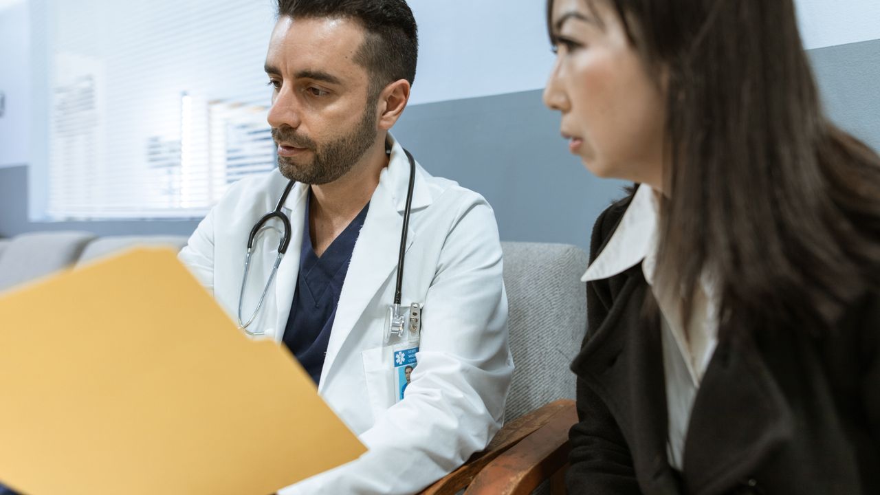Doctor in a white coat talking with a patient in a bright clinic