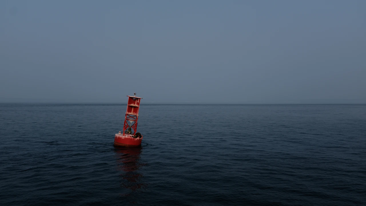 Red navigation buoy floating on a calm sea