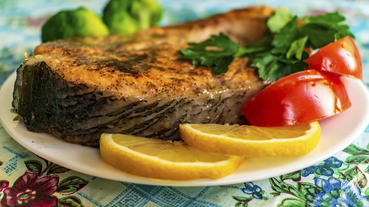 Grilled fish steak with lemon slices and salad on a plate