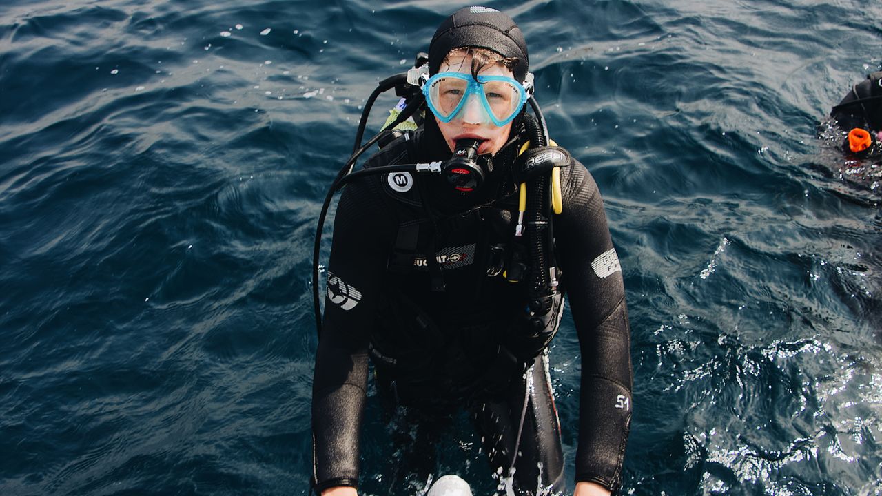 Scuba diver in a wetsuit and mask at the surface before a dive