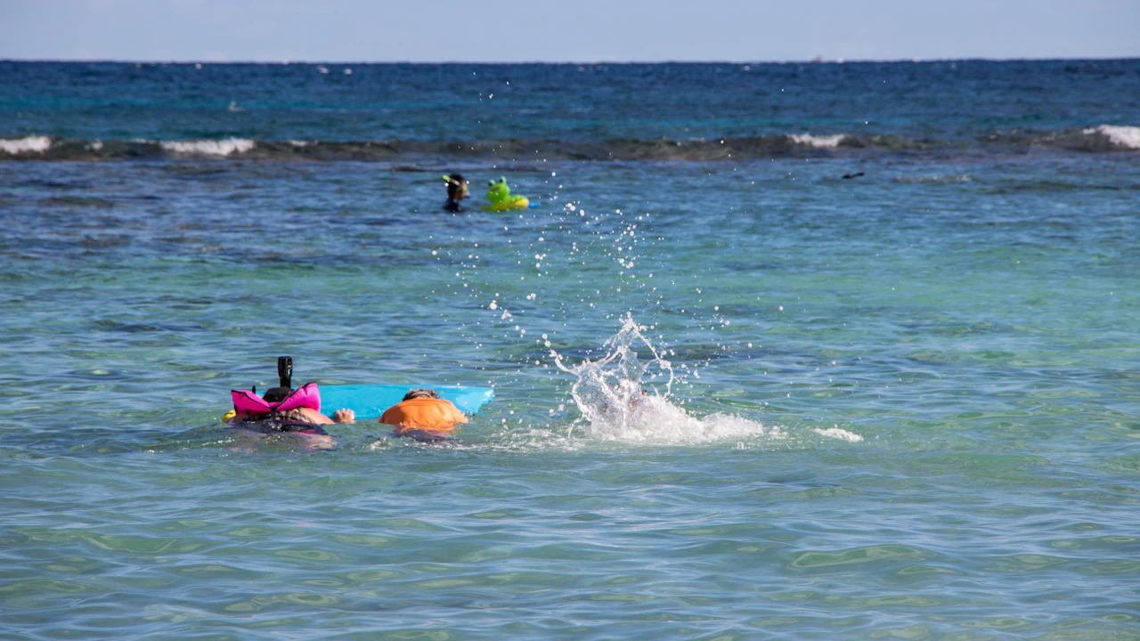 Swimmers with floats in calm water near the shore