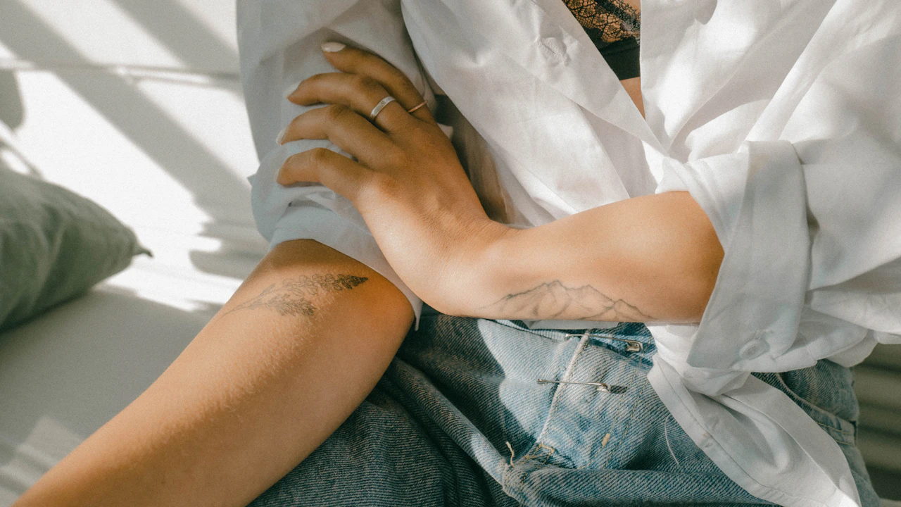 Person resting a bare forearm on their knee