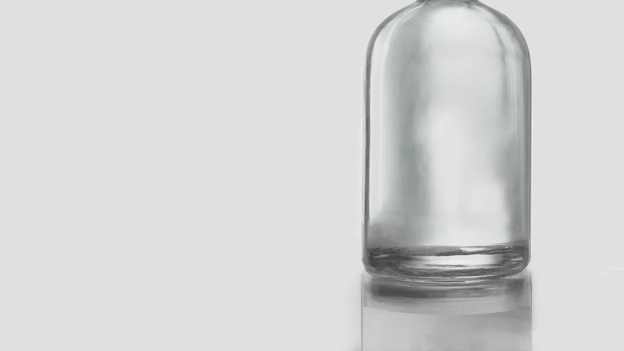 Empty glass bottle on a white surface