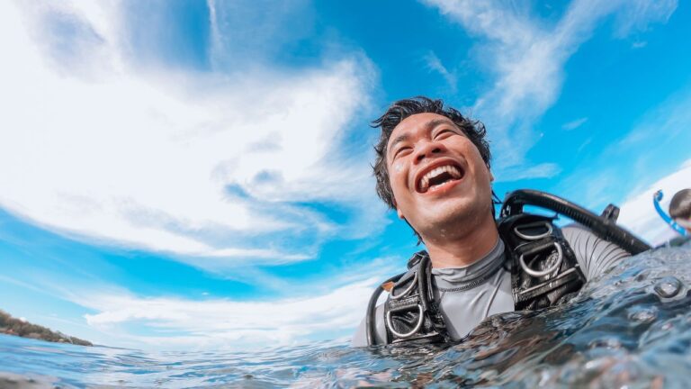 Beginner diver in a mask floating at the surface and smiling before a dive