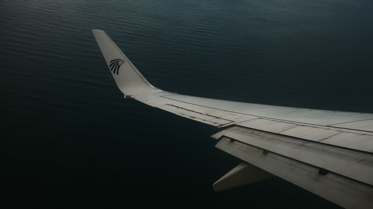 View from an airplane window of a wing over the sea