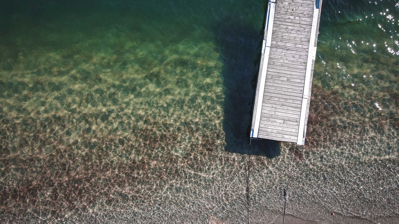 Aerial view of a narrow dock over shallow water