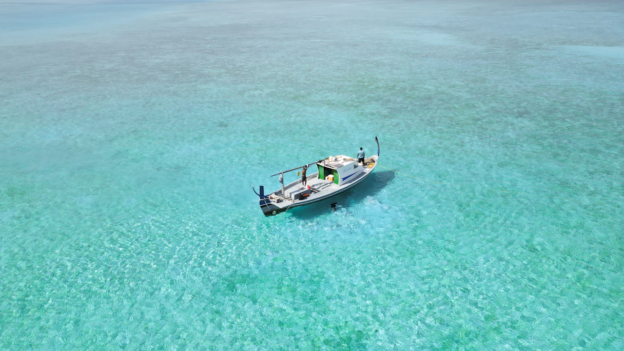 Small dive boat anchored on calm turquoise water on a sunny day