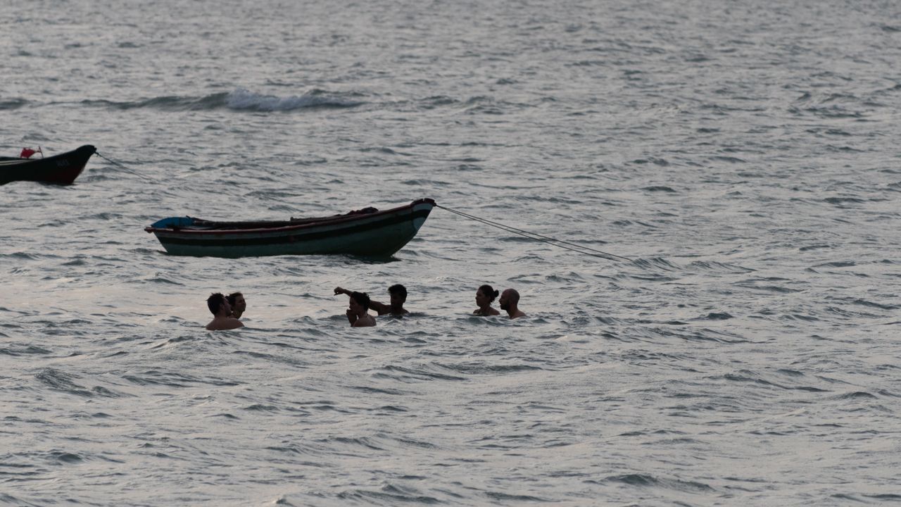 Swimmers in the sea near small boats