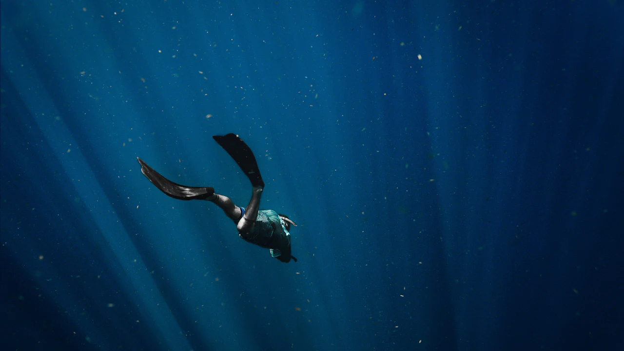 Diver fins kicking through blue water
