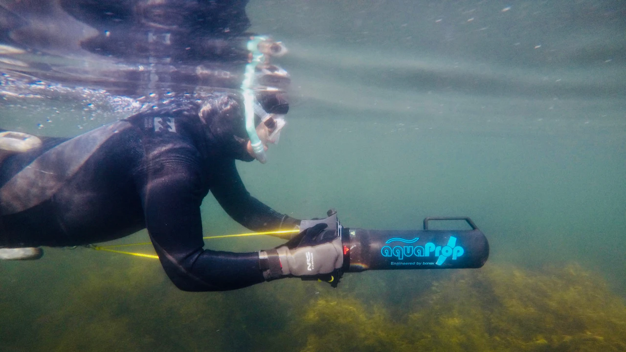 Diver riding an underwater scooter in shallow water