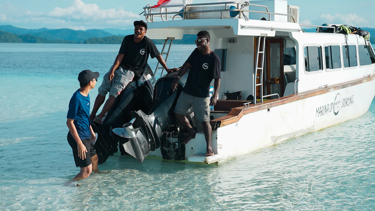 People loading gear onto a boat at the beach