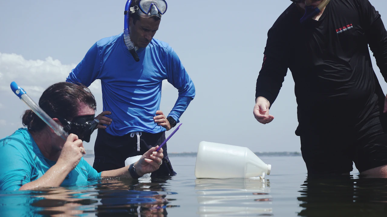 Instructor and students standing in shallow water