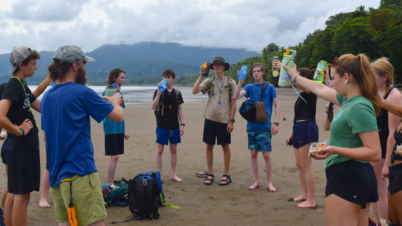 Group of travelers talking together on a sandy beach