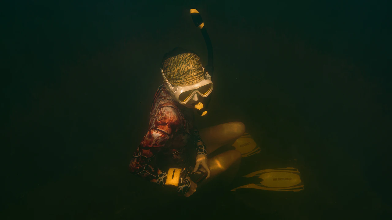 Close view of a scuba diver's face behind a low profile mask underwater