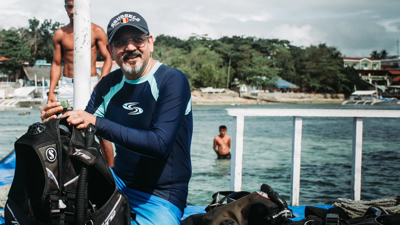 Smiling diver getting his gear ready on a boat