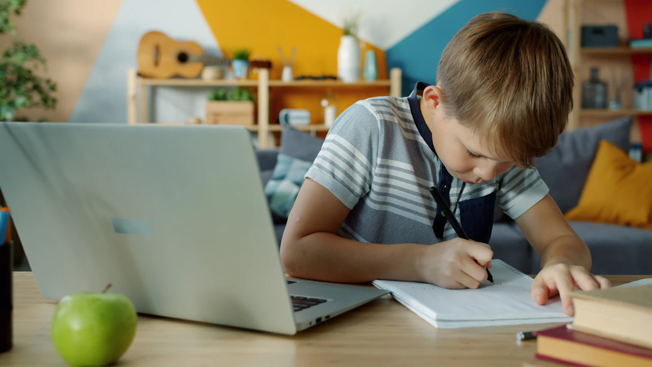 Child studying on a laptop at a table