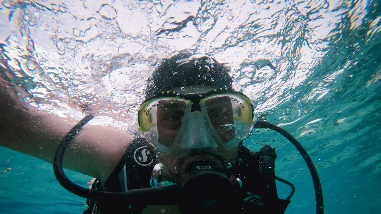 Scuba diver in a mask and regulator just below the surface