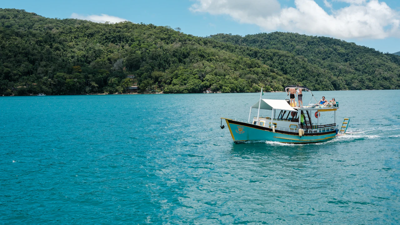 Small boat on calm turquoise water near a green coast