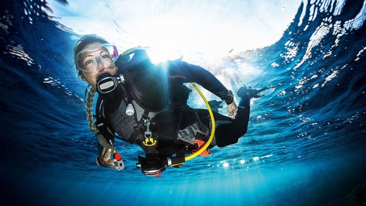 Scuba diver swimming underwater near the surface