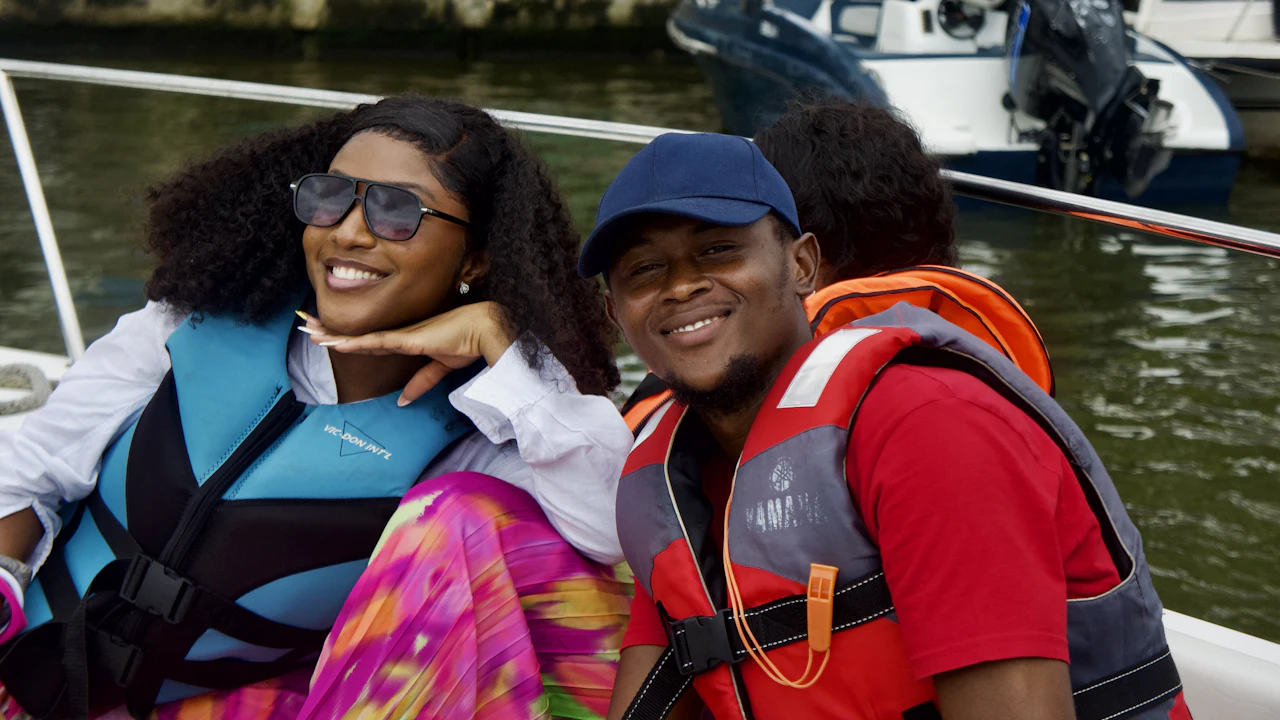 Two smiling people in life jackets on a boat